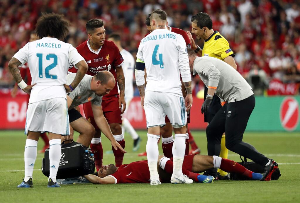 Liverpool's Mohamed Salah grimaces on the ground after injuring himself during the Champions League Final soccer match between Real Madrid and Liverpool at the Olimpiyskiy Stadium in Kiev, Ukraine, Saturday, May 26, 2018. (AP Photo/Pavel Golovkin)