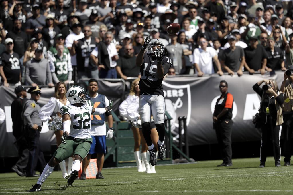 Oakland Raiders wide receiver Michael Crabtree catches a touchdown pass against New York Jets cornerback Juston Burris (32) during the first half in Oakland, Sunday, Sept. 17, 2017. (AP Photo/Marcio Jose Sanchez)