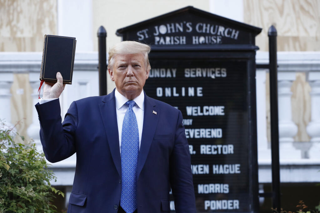 FILE - In this June 1, 2020, file photo President Donald Trump holds a Bible as he visits outside St. John's Church across Lafayette Park from the White House in Washington. An internal investigation has determined that the decision to clear racial justice protestors from an area in front of the White House last summer was not influenced by then-President Donald Trump’s plans for a photo opportunity at that spot. The report released Wednesday by the Department of Interior’s Inspector General concludes that the protestors were cleared by U.S. Park Police on June 1 of last year so new fencing could be installed. (AP Photo/Patrick Semansky, File)