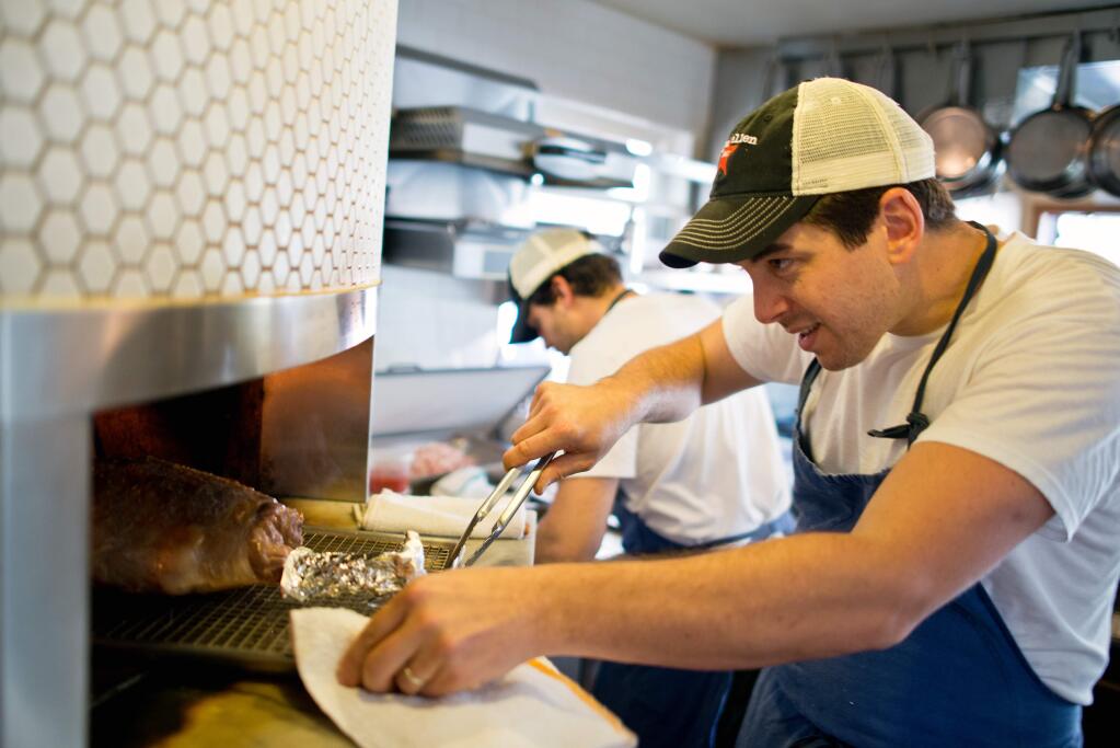 Chef Ari Weiswasser places a leg of lamb into the wood oven at the Glen Ellen Star restaurant in 2013. (PD FILE)