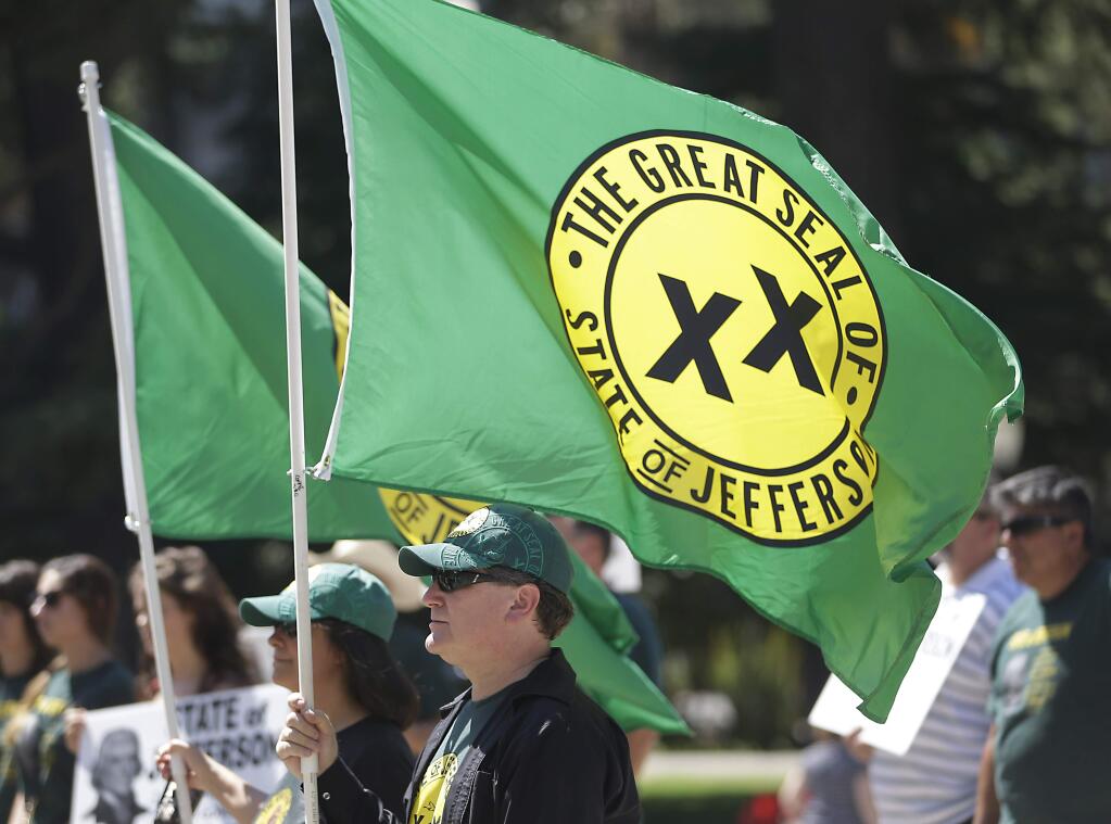 With flags showing the double XX, representing the state of Jefferson, fluttering in the breeze, dozens of residents from several rural counties rallied at the Capitol calling for the creation of the 51st state Thursday, Aug. 28, 2014, in Sacramento, Calif. (AP Photo/Rich Pedroncelli) r