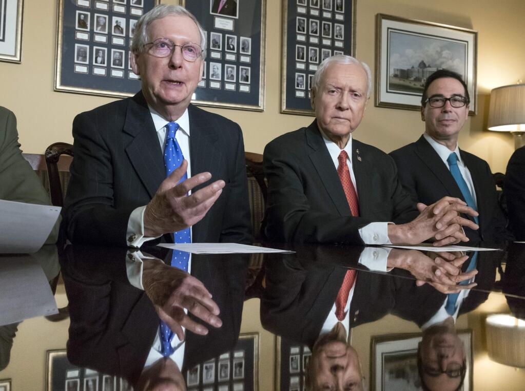 In this Nov. 9, 2017, photo, from left, Senate Majority Leader Mitch McConnell, R-Ky., Senate Finance Committee Chairman Orrin Hatch, R-Utah, and Treasury Secretary Steven Mnuchin, speak to reporters as work gets underway on the Senate's version of the GOP tax reform bill, on Capitol Hill in Washington. The House and Senate tax overhaul plans are broadly similar, but crucial differences create headaches for Republican leaders determined to keep myriad interest groups and factions of the GOP satisfied. (AP Photo/J. Scott Applewhite)