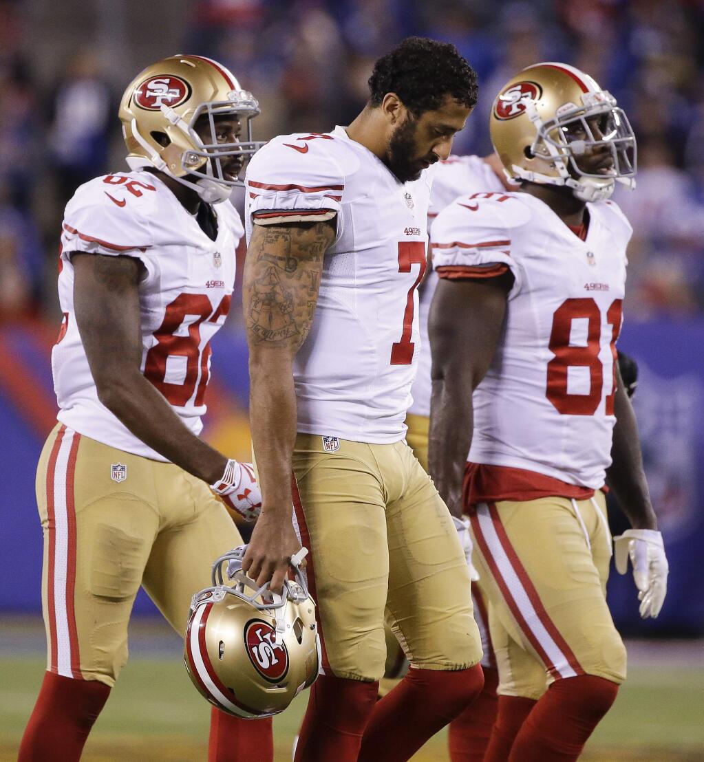 San Francisco 49ers quarterback Colin Kaepernick (7) walks off the field with wide receiver Torrey Smith (82) and wide receiver Anquan Boldin (81) during the fourth quarter of an NFL football game against the New York Giants, Sunday, Oct. 11, 2015, in East Rutherford, N.J. (AP Photo/Seth Wenig)
