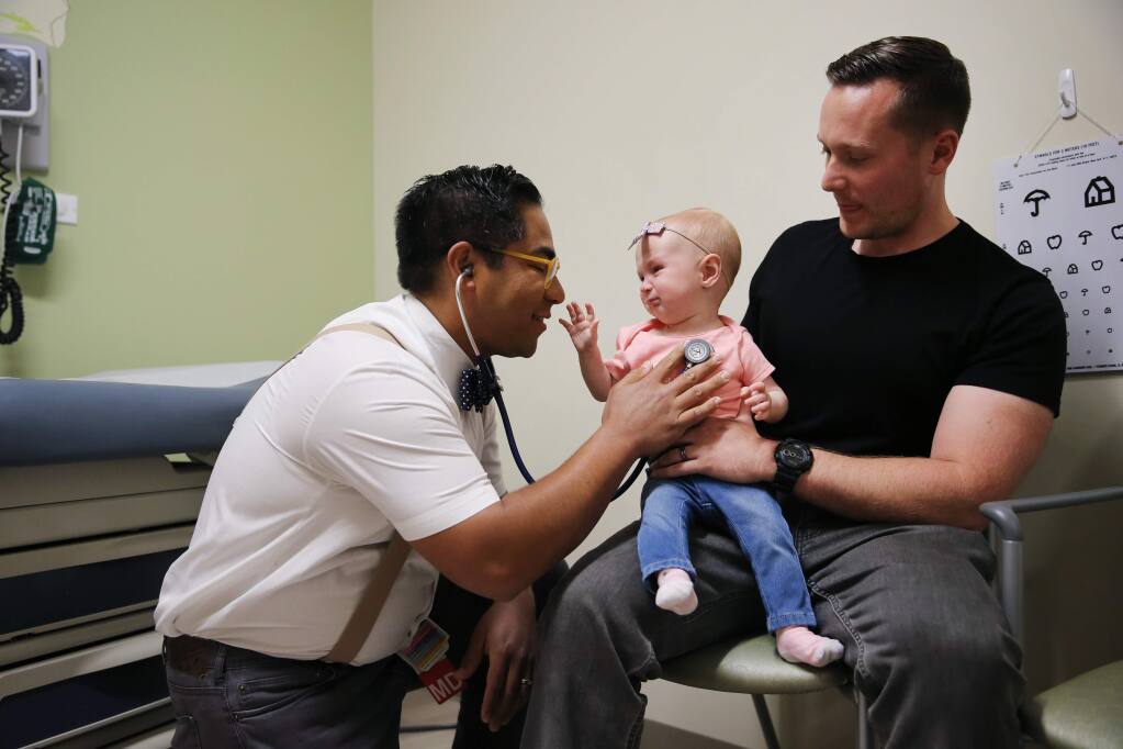 Dr. Brian Prystowsky uses a stethoscope to listen to Addison Vallee's chest while she is held by her father Tyler Vallee during her 9-month wellness exam at Sutter Pacific Medical Foundation in Santa Rosa, California on Wednesday, May 8, 2019. Addison is currently up-to-date on all of her vaccinations. (BETH SCHLANKER/The Press Democrat)