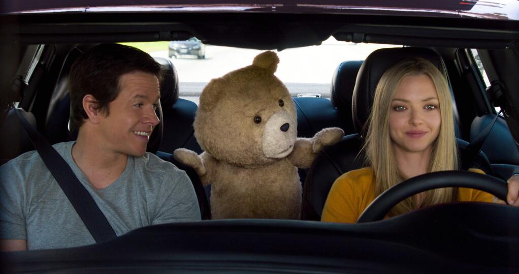 In this image released by Universal Pictures, Mark Wahlberg , from left, the character Ted, voiced by Seth MacFarlane, and Amanda Seyfried appear in a scene from 'Ted 2.' (Universal Pictures via AP)