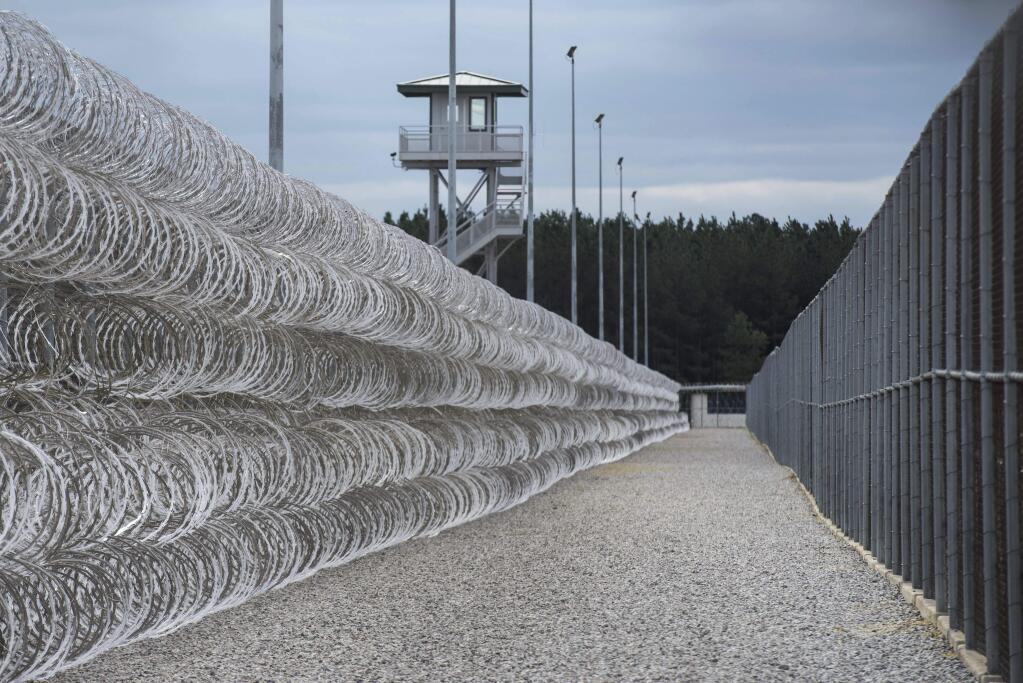 FILE - In this Feb. 9, 2016, file photo, razor wire protects a perimeter of the Lee Correctional Institution in Bishopville, S.C. A South Carolina prisons spokesman says several inmates are dead and others required outside medical attention after hours of fighting inside the maximum security prison. (AP Photo/Sean Rayford, File)