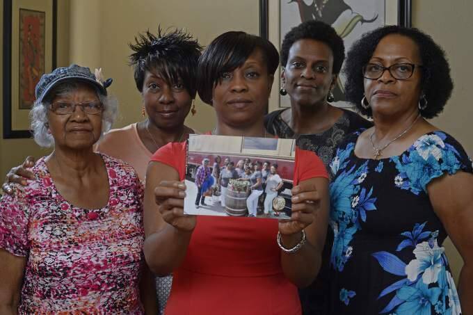 Five of the 11 members of the Sistahs on the Reading Edge book club who were booted off the Napa Valley Wine Train. Lisa Renee Johnson holds a photograph of the group that was taken before boarding the train. (JOSE CARLOS FAJARDO / Bay Area News Group)