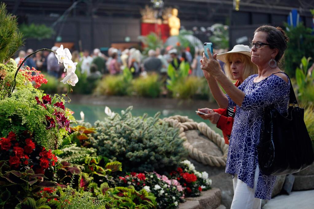 Cici Davidson of Little Rock, Arkansas, right, and Ann Vestal of Clayton snap photos of floral displays during the Hall of Flowers preview at the Sonoma County Fairgrounds in Santa Rosa, California on Thursday, July 21, 2016. This year's theme for the Hall of Flowers is 'Sonoma Cinema' with displays based on movies filmed in Sonoma County. (Alvin Jornada / The Press Democrat)