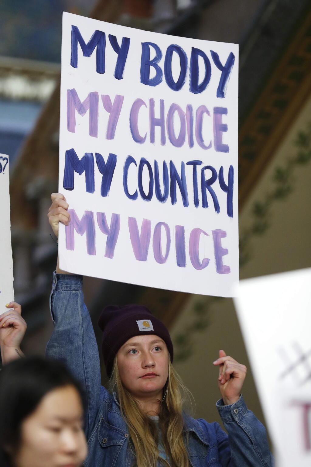 Tevka Lackmann, of Norwalk, Iowa, holds a sign during a rally to protest recent abortion bans, Tuesday, May 21, 2019, at the Statehouse in Des Moines, Iowa. (AP Photo/Charlie Neibergall)
