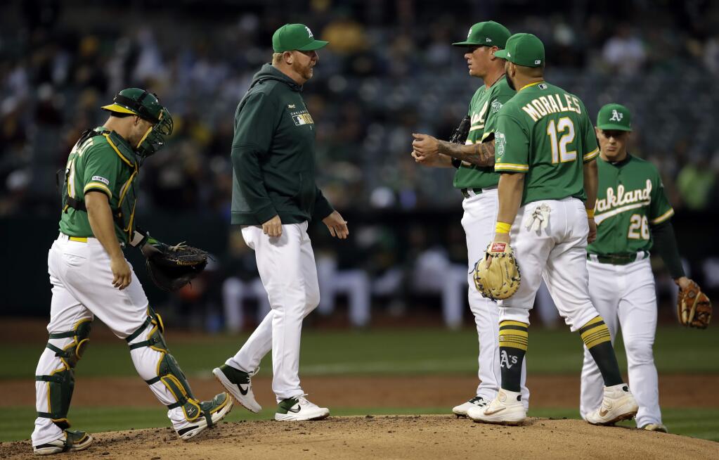 Oakland Athletics pitching coach Scott Emerson, second from left, speaks with pitcher Aaron Brooks in the second inning of a baseball game against the Toronto Blue Jays, Friday, April 19, 2019, in Oakland, Calif. (AP Photo/Ben Margot)
