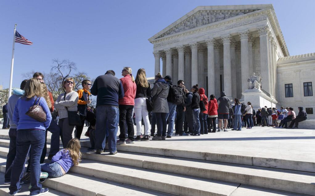Visitors wait on the plaza of the Supreme Court in Washington, Tuesday, March 29, 2016, as the justices split 4-4 in a case that considered whether public employees represented by a union can be required to pay 'fair share' fees covering collective bargaining costs even if they are not members. The deadlock is the first tie vote since the death of Justice Antonin Scalia, who had been expected to rule against the unions, and now leaves in place an appeals court ruling that upheld the practice. (AP Photo/J. Scott Applewhite)