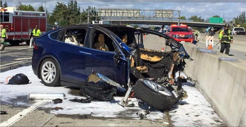 FILE - In this March 23, 2018, file photo provided by KTVU, emergency personnel work a the scene where a Tesla electric SUV crashed into a barrier on U.S. Highway 101 in Mountain View, Calif. The National Transportation Safety Board has issued a safety recommendation urging California transportation officials to move faster to repair highway safety barriers damaged by vehicles. The NTSB recommendation Monday, Sept. 9, 2019 comes in a report that says California officials failed to fix a highway safety barrier before the fatal March, 2018 collision that killed an Apple engineer driving in Autopilot mode. The barrier had been damaged 11 days earlier. (KTVU-TV via AP, File)
