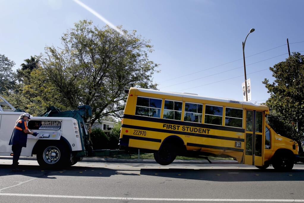A school bus is towed after being involved in an accident with a car on Sonoma Aveue near Santa Rosa Avenue in Santa Rosa, on Tuesday, July 14, 2015. (BETH SCHLANKER/ PD)