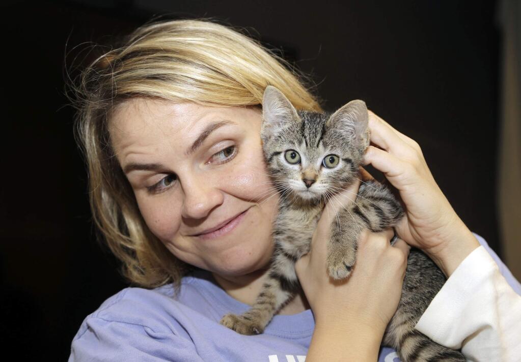 Laura Moran holds a kitten at Warner Bros. Studio that was delivered by Uber in Burbank, Calif., Thursday, Oct. 29, 2015. The ride-hailing service promised kittens for what they called the best 15-minute snuggle available for $30. (AP Photo/Nick Ut)