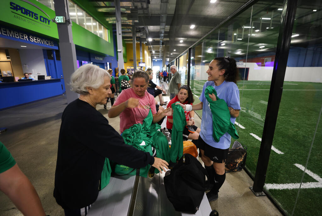 Players from the C- Book Club recreation league soccer team grab jerseys before their game at Epicenter Sports and Entertainment in Santa Rosa on Tuesday, June 15, 2021.  (Christopher Chung/ The Press Democrat)