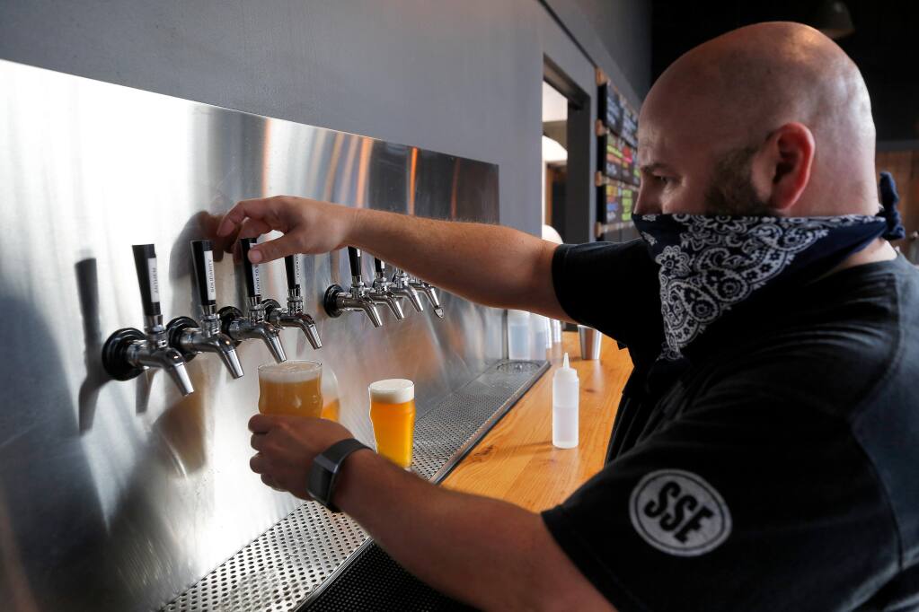 Brewer/co-owner Chris Adamian pours beer for a customer's order at Corner Project Ales and Eats in Geyserville, California, on Friday, July 31, 2020. (Alvin Jornada / The Press Democrat)