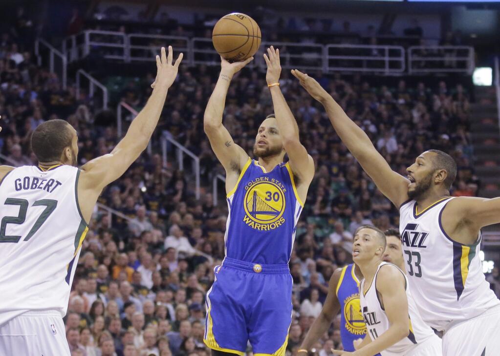 Golden State Warriors guard Stephen Curry (30) shoots as Utah Jazz's Rudy Gobert (27) and Boris Diaw (33) defend in the first half during Game 4 of the NBA basketball second-round playoff series, Monday, May 8, 2017, in Salt Lake City. (AP Photo/Rick Bowmer)