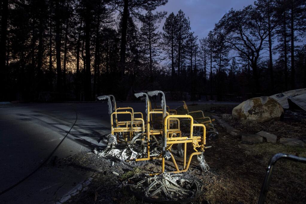FILE - In this Dec. 4, 2018, file photo, scorched wheelchairs rest outside Cypress Meadows Post-Acute, a nursing home leveled by the Camp Fire in Paradise, Calif. (AP Photo/Noah Berger, File)
