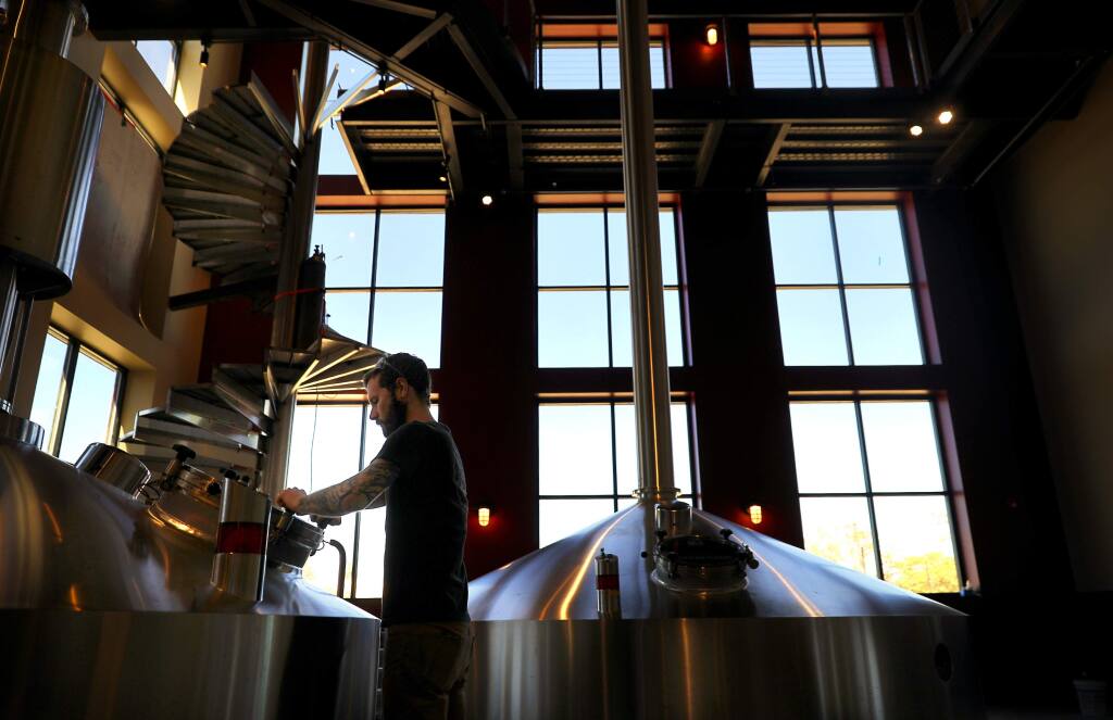 Lead brewer Zach Kelly prepares to add hops to a tank of Consecration in the brew house of the new Russian River Brewing Company brewery and restaurant facility, under construction in Windsor on Monday, September 17, 2018. (Christopher Chung/ The Press Democrat)