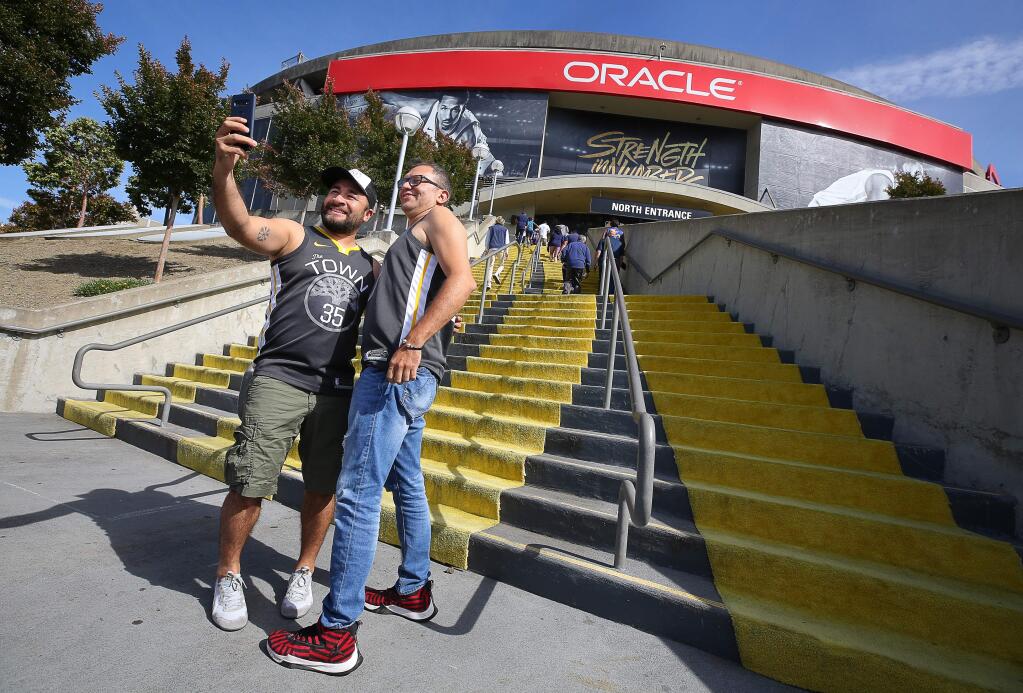 Erick Estrada, left, and Miguel Arbaol take a selfie before going into Oracle Arena to watch the Golden State Warriors take on the Toronto Raptors in game 3 of the NBA Finals in Oakland on Wednesday, June 5, 2019. (Christopher Chung/ The Press Democrat)