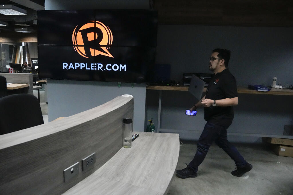 A reporter of Rappler walks inside their office in Pasig city, Philippines on Wednesday, June 29, 2022. Filipino journalist and Nobel Peace Prize winner Maria Ressa said her Rappler news website was operating “business as usual” Wednesday and would let Philippine courts decide on a government order to close the outlet critical of the outgoing Duterte administration and its deadly drug crackdown. (AP Photo/Aaron Favila)
