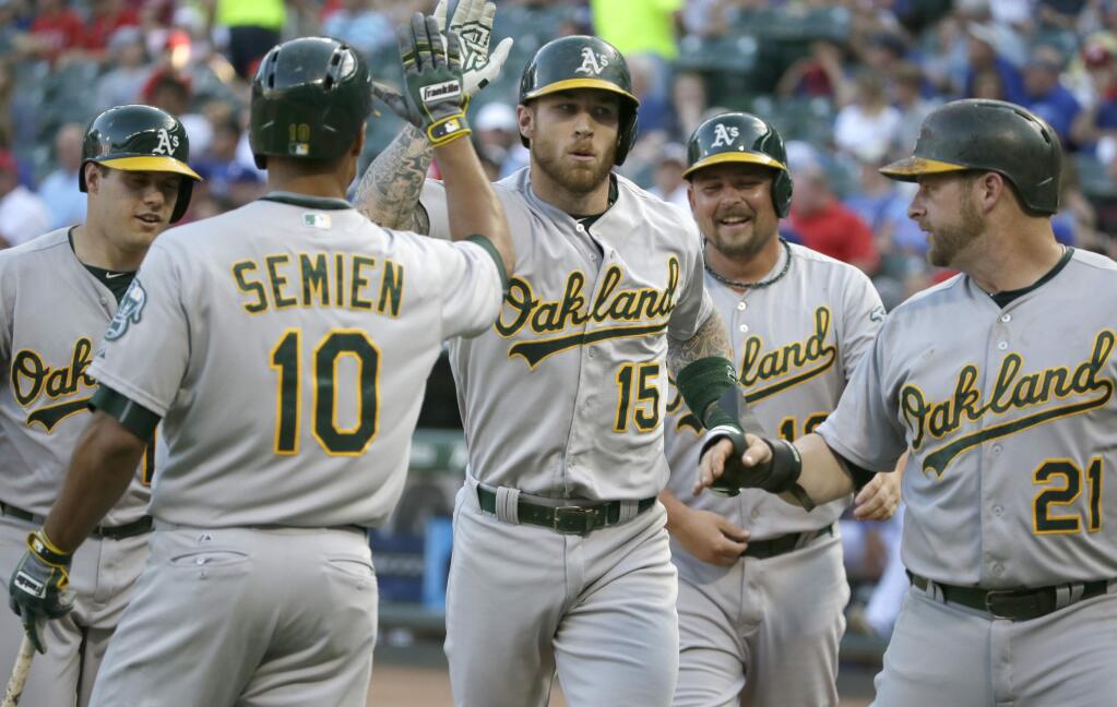 Oakland Athletics Brett Lawrie (15) celebrates his grand slam home run with teammates Stephen Vogt (21), Billy Butler, second from right, and Marcus Semien (10) during the first inning of a baseball game against the Texas Rangers in Arlington, Texas, Wednesday, June 24, 2015. (AP Photo/LM Otero)