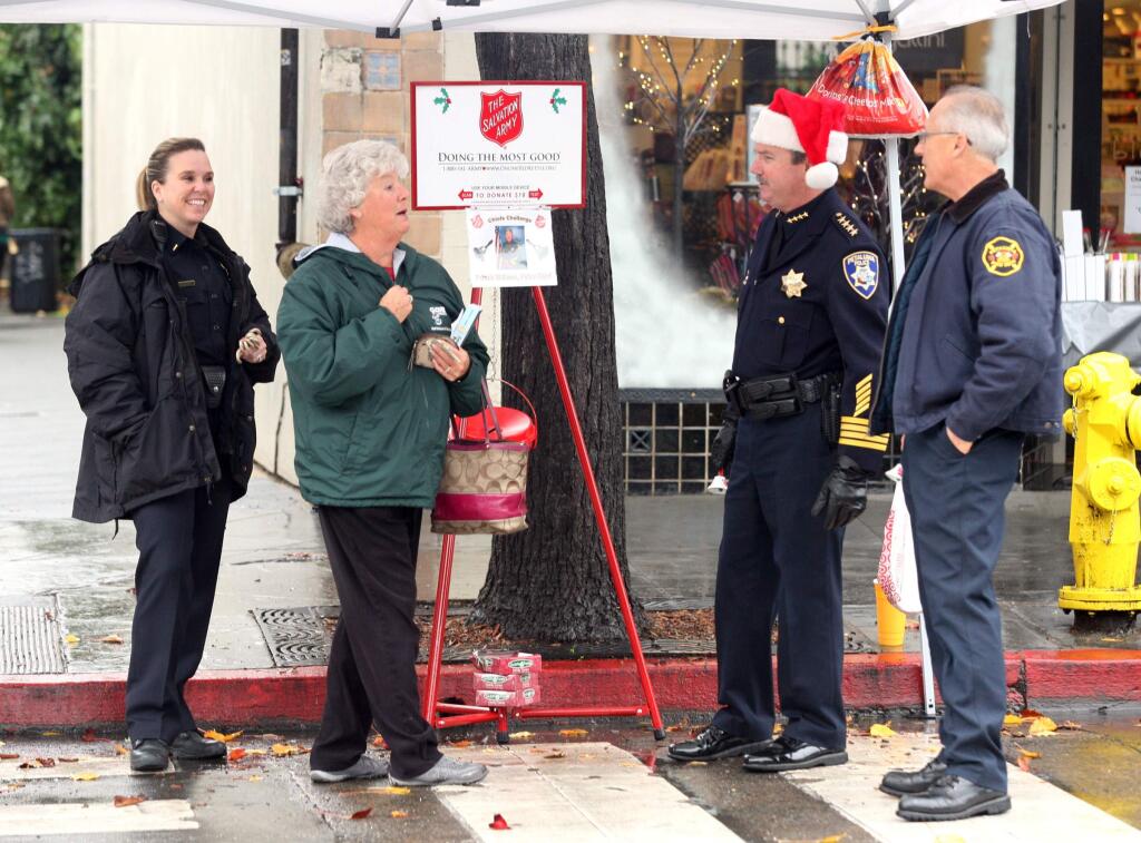 Petaluma's Chiefs, Chief of Police Patrick Williams, wearing santa's hat, and helped by Police Lt. Tara Salizzoni and Fire Chief Larry Anderson, right, took to Kentucky Street to raise money in the annual Chief's Kettle Challenge on Friday December 19, 2014. (SCOTT MANCHESTER/ARGUS-COURIER STAFF)