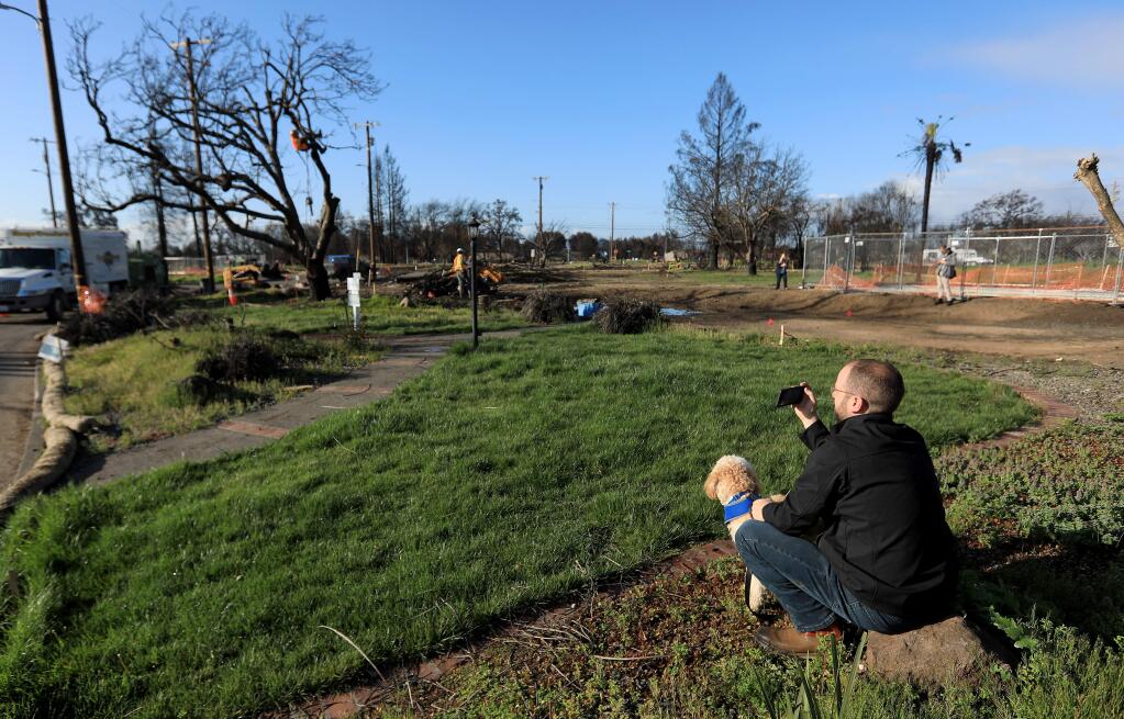 Brad Sherwood, Friday March 23, 2018, watches as crews cut down an English walnut tree on his burned home site, damaged by the October Tubbs fire in Larkfield. (Kent Porter / Press Democrat) 2018