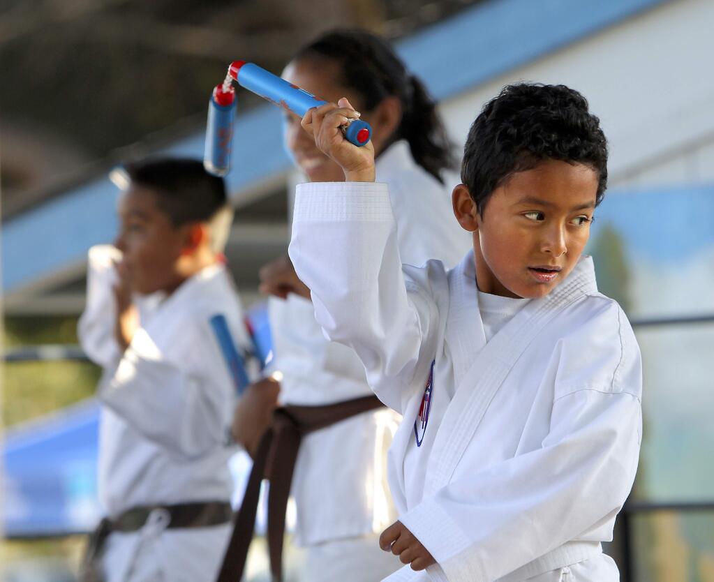 Kevin Bacera, 7, shows off his taekwondo skills with the Martial Arts Youth Institute at the South Park Summer Day and Night festival in Santa Rosa on Saturday, Aug. 9, 2014.