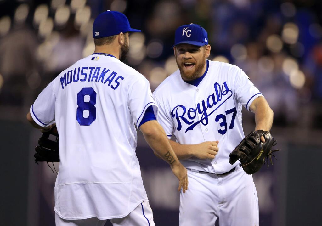 Kansas City Royals third baseman Mike Moustakas, left, and first baseman Brandon Moss, right, celebrate following a game against the Detroit Tigers at Kauffman Stadium in Kansas City, Mo., Tuesday, Sept. 26, 2017. (AP Photo/Orlin Wagner)