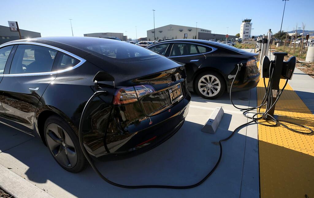 Electric vehicles are plugged in to the new charging stations in the long term lot at the Charles M. Schulz Sonoma County Airport, Thursday, Dec. 13, 2018 in Santa Rosa. (Kent Porter / The Press Democrat) 2018