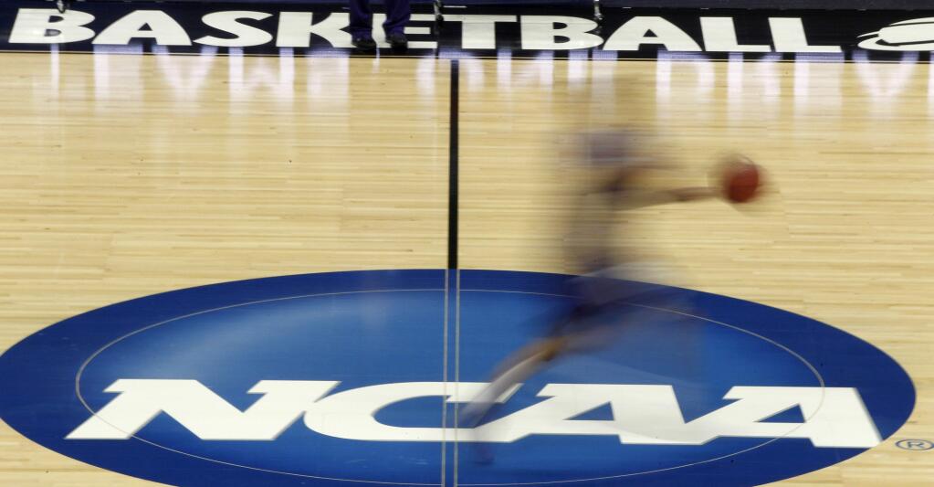In this March 14, 2012, file photo, a player runs across the NCAA logo during practice in Pittsburgh before an NCAA tournament game. (AP Photo/Keith Srakocic, File)