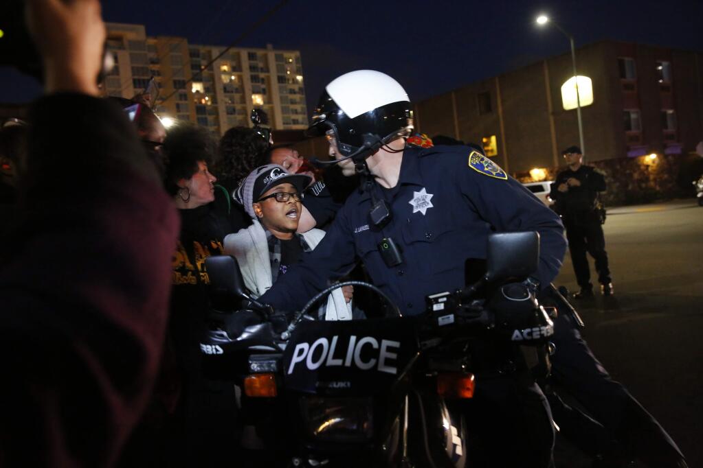 In this May 23, 2015 photo, protesters push against Oakland police as they attempt to continue marching in Oakland, Calif. About 100 people took to the streets in Oakland on Saturday night to protest against what they said was the city's crackdown on nighttime demonstrations. (Leah Millis/San Francisco Chronicle via AP) MANDATORY CREDIT PHOTOG & CHRONICLE; MAGS OUT; NO SALES