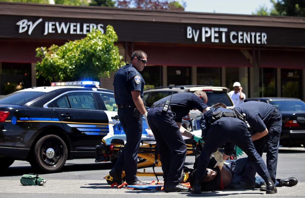 A suspect is taken by ambulance after a robbery at Bennett Valley Jewelers in Santa Rosa, Thursday, July 10, 2014. (PD FILE, 2014)