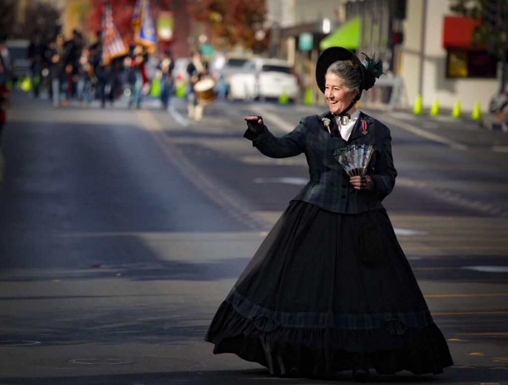 Cindy Eddy of the Sonoma County Auxiliary to Sons of Union Veterans of Civil War waves to the crowds that gathered to celebrate and honor Veterans Day in downtown Petaluma on Nov. 11, 2019. (Crissy Pascual/Argus-Courier)
