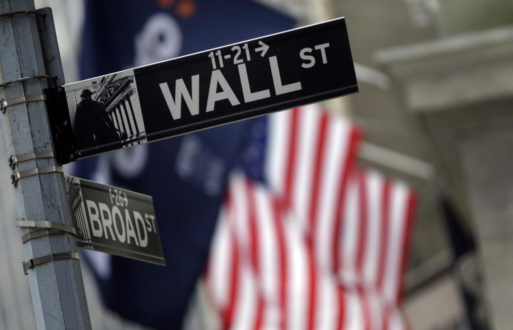FILE - This Oct. 2, 2014 file photo shows a Wall Street sign adjacent to the New York Stock Exchange, in New York. (AP Photo/Richard Drew, File)