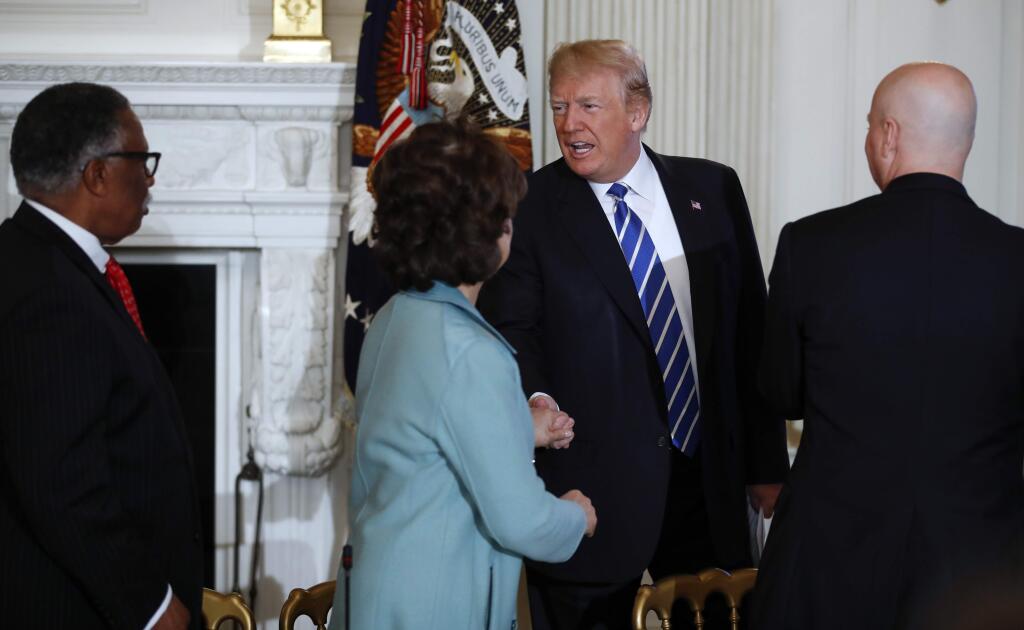 President Donald Trump is greeted by Vicksburg, Miss., Mayor George Flaggs, Jr., left, Secretary of Transportation Elaine Chao, second from left, and Nebraska Gov. Pete Ricketts, right, as he arrives for an infrastructure meeting in the State Dining Room of the White House in Washington, Monday, Feb. 12, 2018. (AP Photo/Carolyn Kaster)