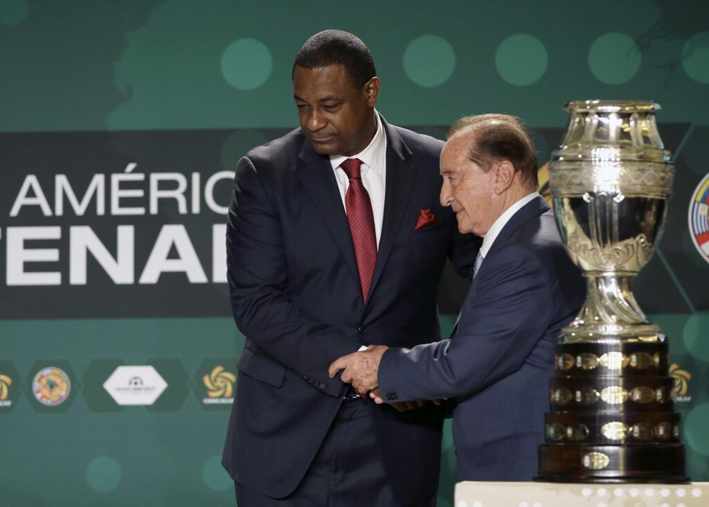 CONCACAF president Jeffrey Webb, left, and Eugenio Figueredo, right, president of CONMEBOL, the South American soccer confederation, shake hands before a news conference in Bal Harbour, Fla., Thursday, May 1, 2014. Webb and Figueredo are two of the more than 10 top soccer officials who were placed under arrest early Wednesday morning in Zurich. (AP Photo/Alan Diaz)