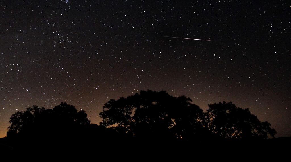 A Perseid meteor burns up in the Earth's atmosphere in this Aug. 13, 2010 photo, taken from Stewarts Point-Skaggs Springs Road above Lake Sonoma. The glow at the bottom of the image is from city lights. (Kent Porter / The Press Democrat, 2010)