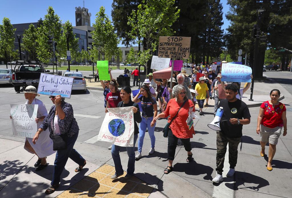 People protesting immigration policies that separate families march along Fourth Street, at Old Courthouse Square, in Santa Rosa on Thursday, June 14, 2018. (Christopher Chung/ The Press Democrat)