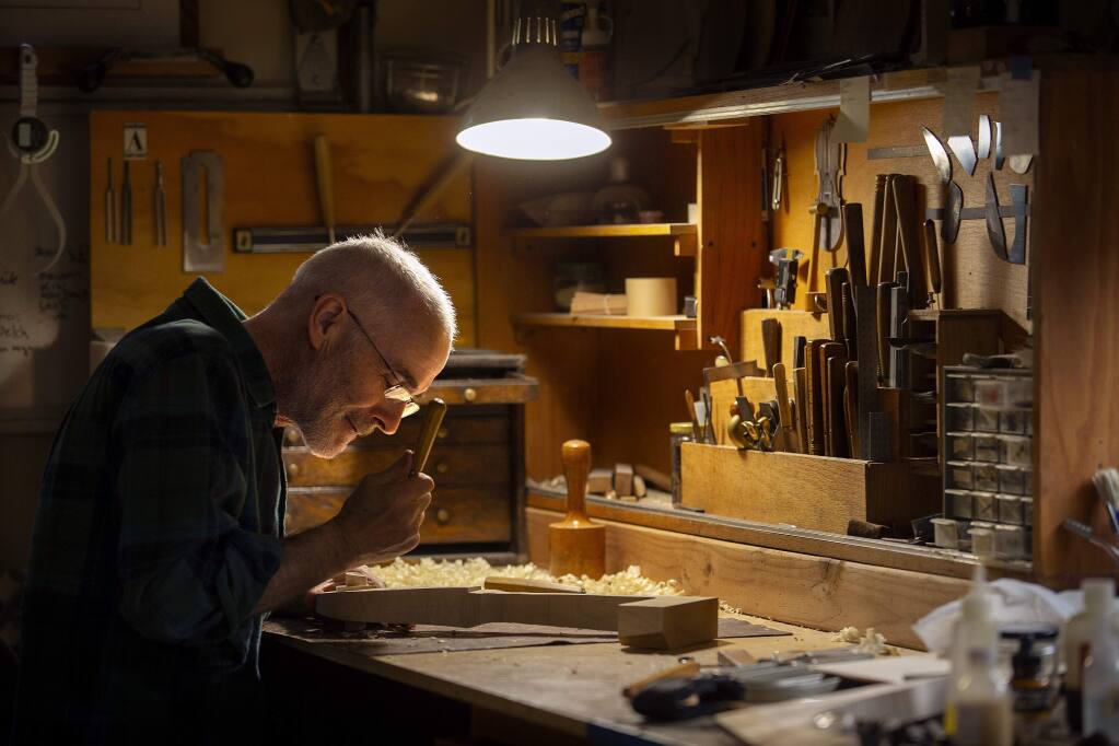 photos by John Burgess / The Press DemocratLuthier Andrew Carruthers hand carves the scroll for a cello in his workshop behind his Santa Rosa home. Carruthers takes about three months to build a cello and six weeks for a violin.