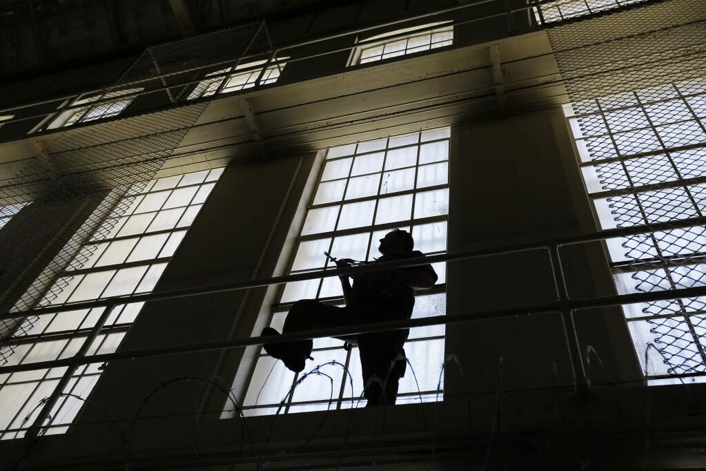 In this photo taken Aug. 16, 2016, a guard keeps watch on the east block of death row at San Quentin State Prison in San Quentin, Calif. California voters have decided to repair the state's dysfunctional death penalty by speeding up appeals. A measure to reform capital punishment continued to hold a 51 percent margin of support Tuesday, Nov. 22, 2016, after two weeks of counting millions of ballots in a contentious race that also saw voters reject a dueling measure to end executions. (AP Photo/Eric Risberg)