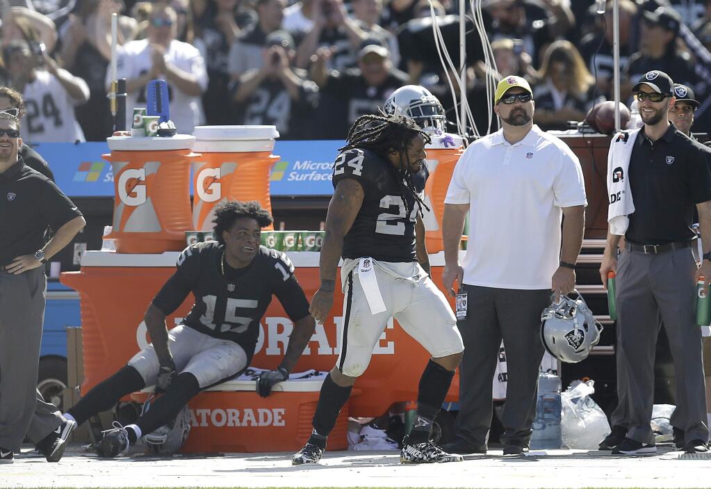 Oakland Raiders running back Marshawn Lynch (24) dances on the sideline as wide receiver Michael Crabtree (15) watches during the second half of an NFL football game against the New York Jets in Oakland, Calif., Sunday, Sept. 17, 2017. (AP Photo/Ben Margot)