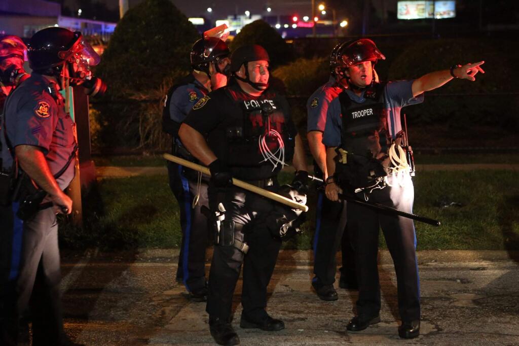 Police point out protesters Monday, Aug. 18, 2014, in Ferguson, Mo. The Aug. 9 shooting of Michael Brown by police has touched off rancorous protests in Ferguson, a St. Louis suburb where police have used riot gear and tear gas. (AP Photo/St. Louis Post-Dispatch, J.B. Forbes)