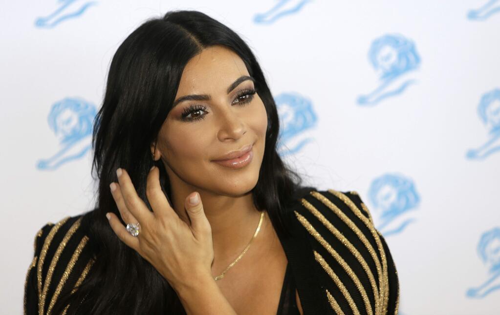 FILE - In this June 24, 2015 file photo, American television personality Kim Kardashian poses for photographers as she attends the Cannes Lions 2015 in Cannes, southern France. The reality TV star is scheduled to speak and sign copies of her new coffee table book ìSelfishî during a Tuesday, June 30 night event hosted by the Commonwealth Club of California, which bills itself as the nation's oldest and largest public affairs forum.(AP Photo/Lionel Cironneau, File)