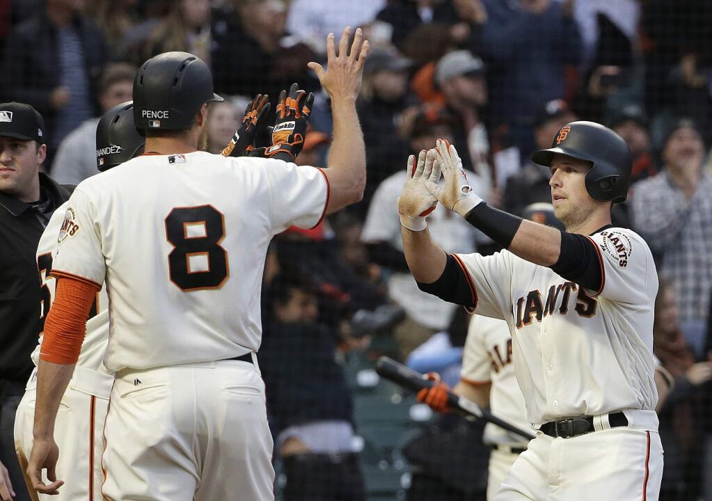The San Francisco Giants' Buster Posey, right, celebrates after hitting a three-run home run that scored Gorkys Hernandez and Hunter Pence, left, against the Chicago Cubs during the first inning in San Francisco, Tuesday, Aug. 8, 2017. (AP Photo/Jeff Chiu)