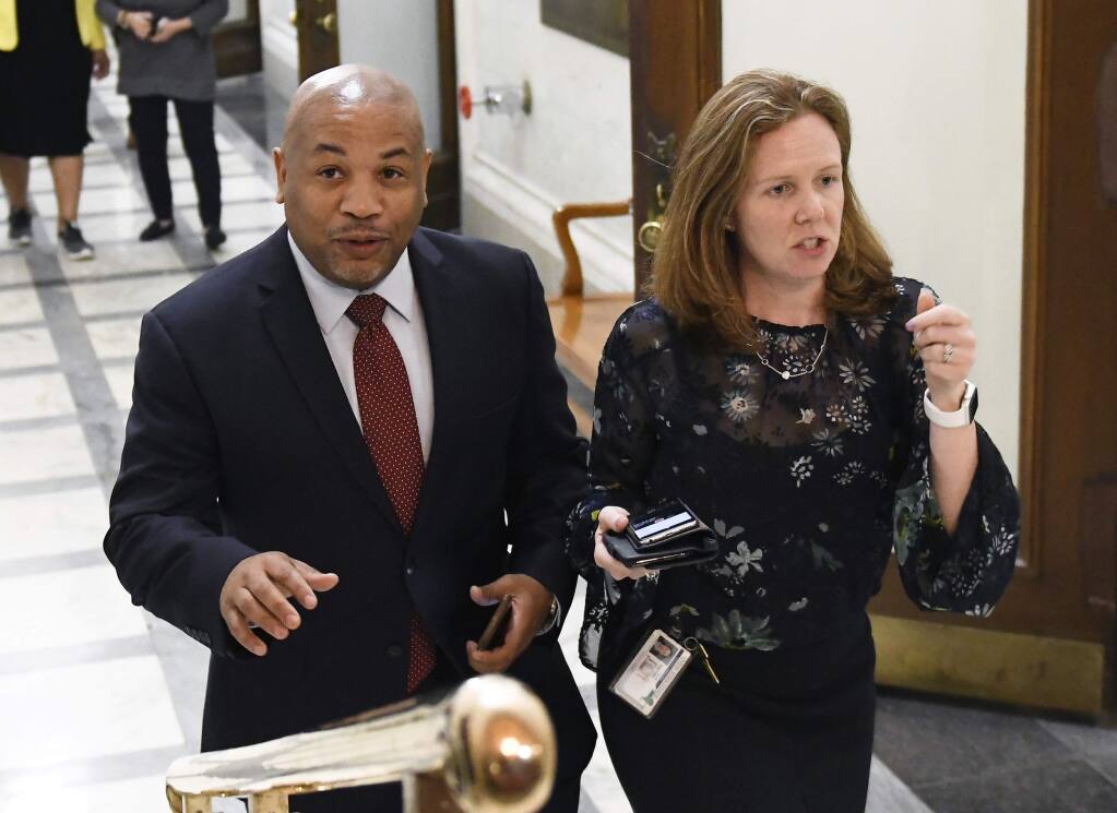 New York Assembly Speaker Carl Heastie, D-Bronx, left, walks with staff member Kerri Biche before talking with reporters about New York Attorney General Eric Schneiderman's resignation at the state Capitol Tuesday, May 8, 2018, in Albany, N.Y. Four women accused Schneiderman of physical violence in a New Yorker article published Monday evening. (AP Photo/Hans Pennink)