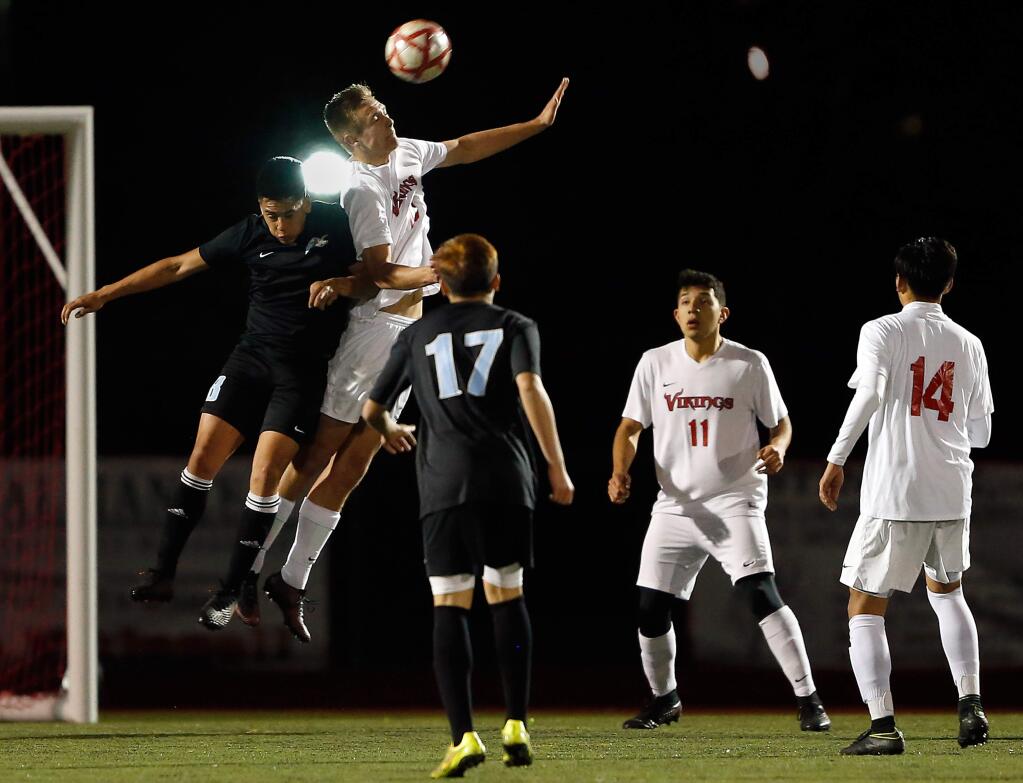 Montgomery's Carson Wyatt (10), second from left, and Tennyson's Eduardo Soto (8) leap for a header during the second half of the NCS Division 2 boys soccer semifinal match on Wednesday, February 22, 2017. (Alvin Jornada / The Press Democrat)