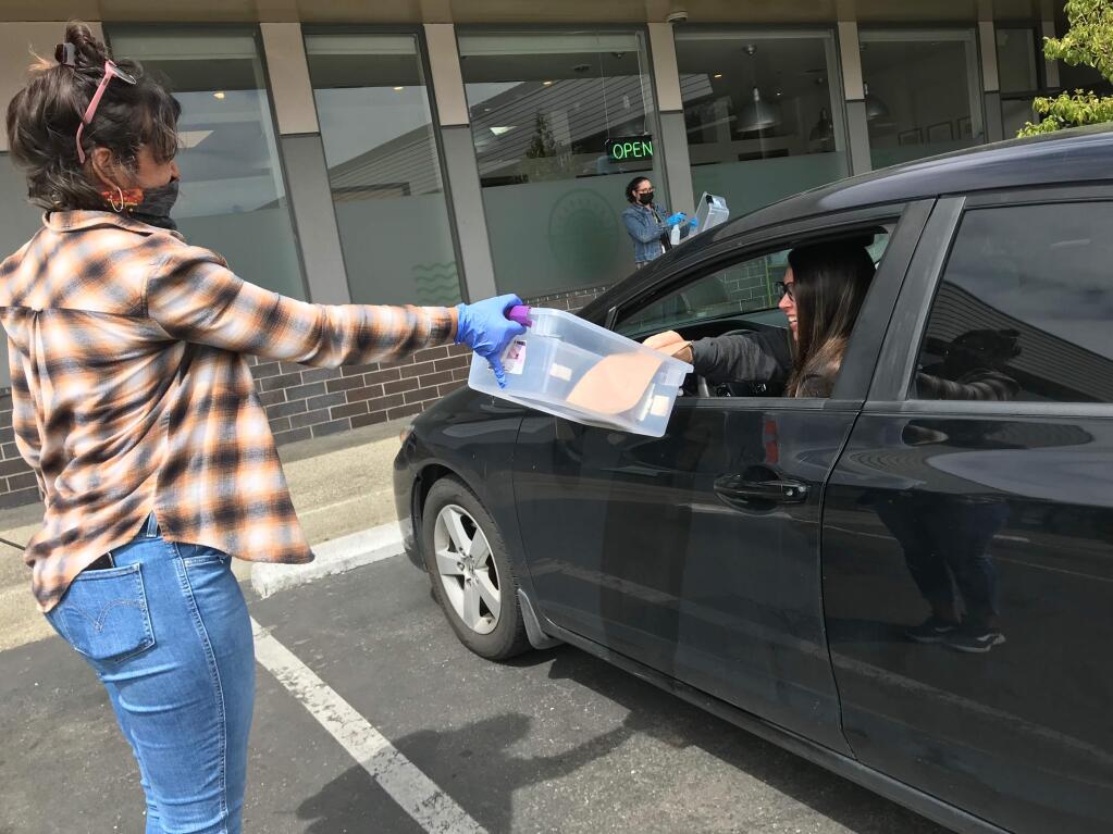 A worker at Solful cannabis store in Sebastopol in Sonoma County hands a customer a purchase. Cash - which some studies suggest could carry the coronavirus - is a prime currency in the trade. (Courtesy photo)