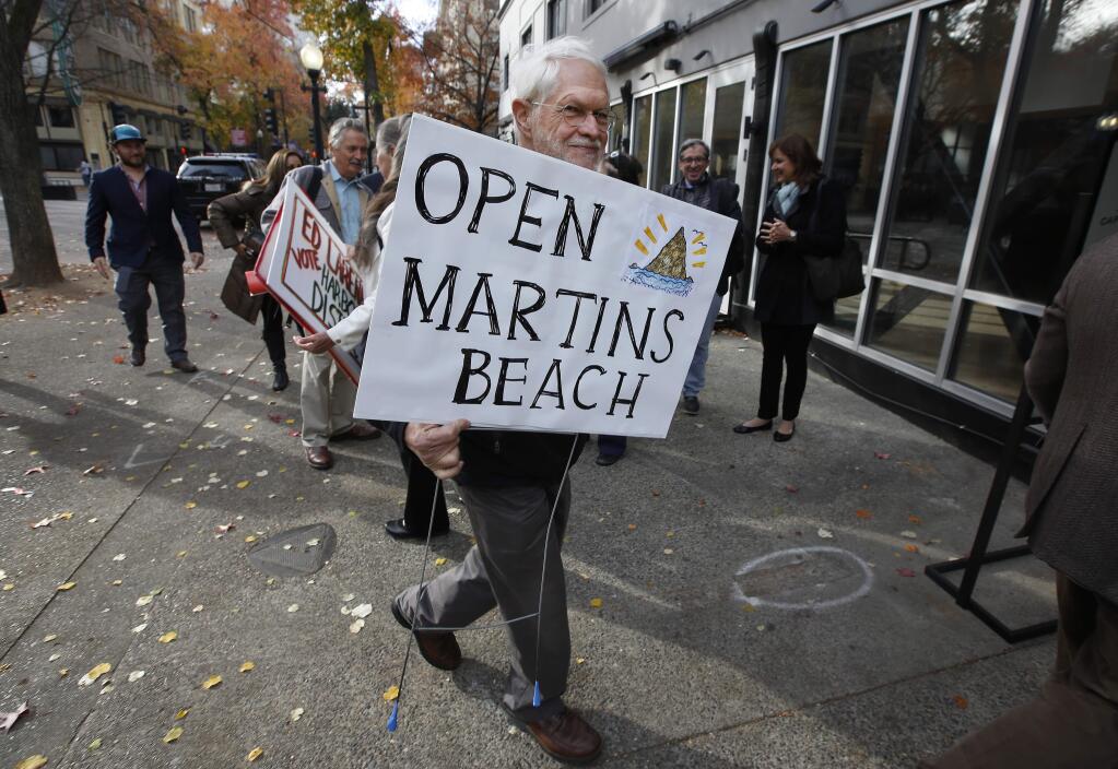 Howard Graves, a supporter of public access to Martin's Beach, carries his sign into a meeting of the State Lands Commission. (RICH PEDRONCELLI / Associated Press, 2016)